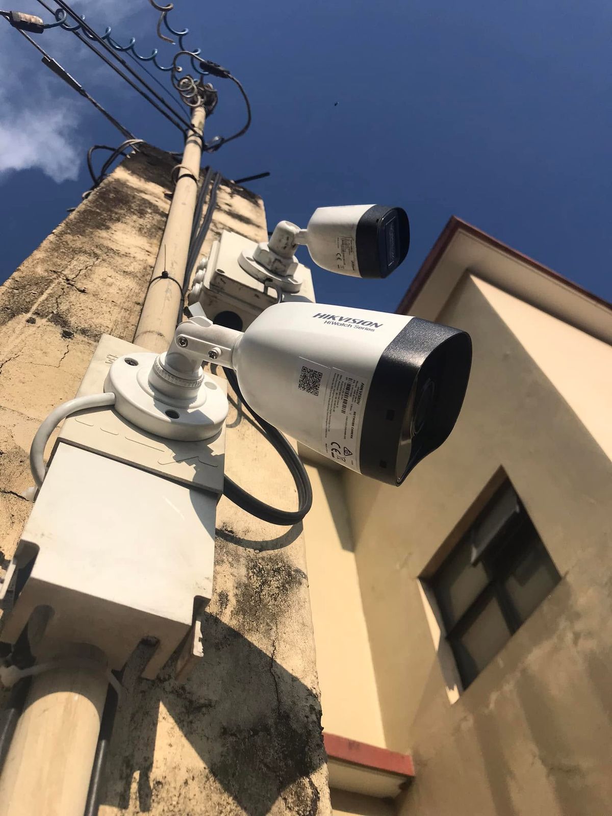 Two Hikvision bullet cameras mounted on an exterior wall